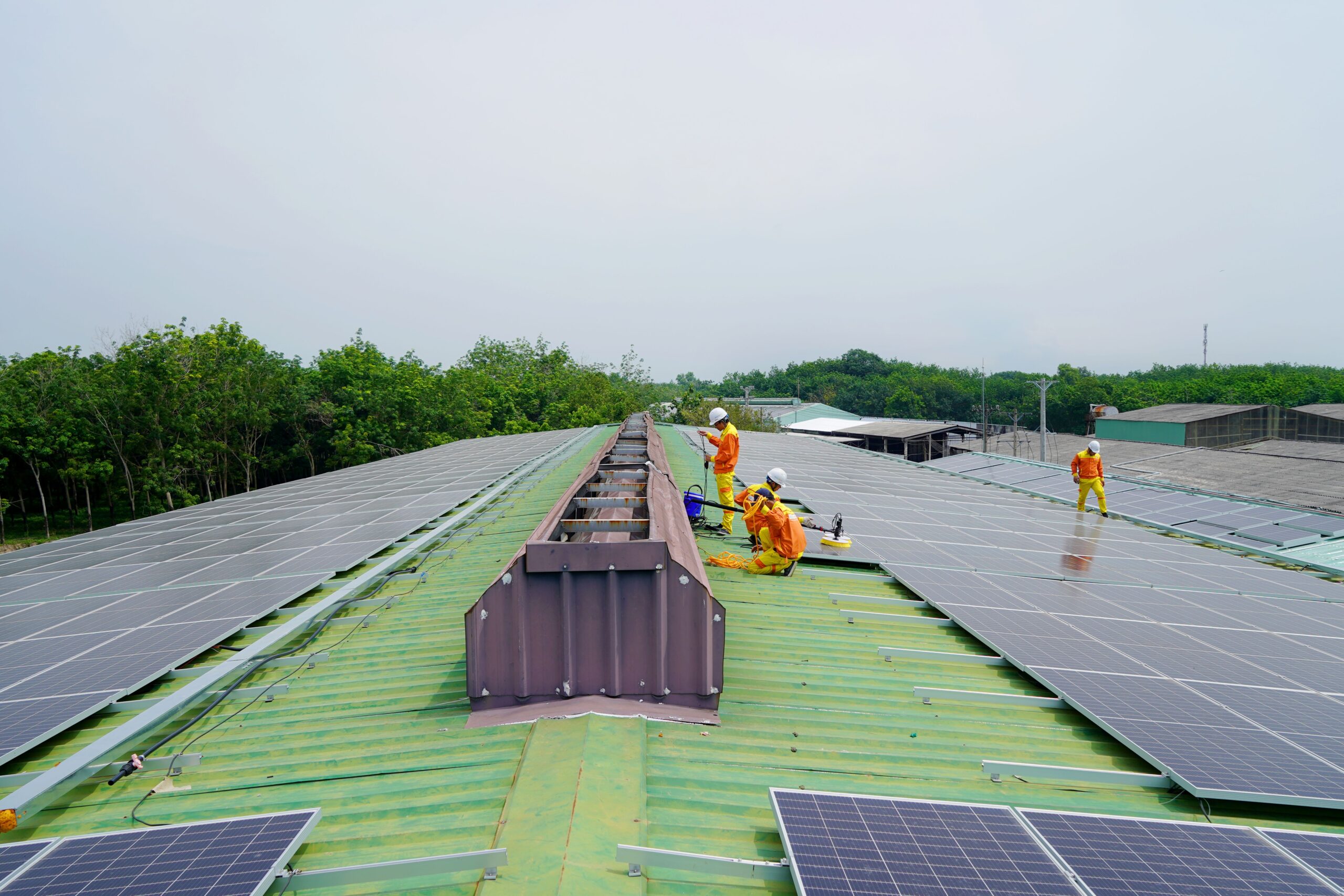Technicians servicing rooftop solar panels
